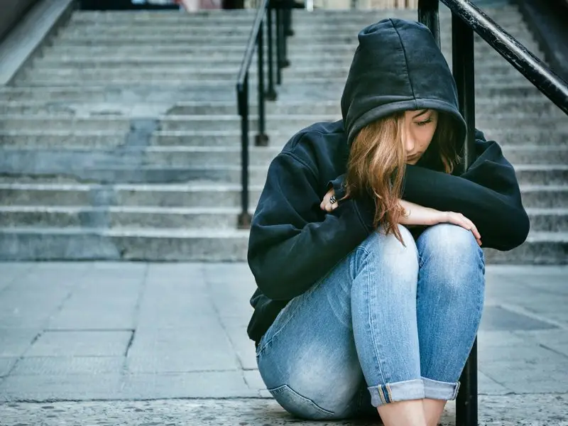 Girl with sweatshirt sitting on steps