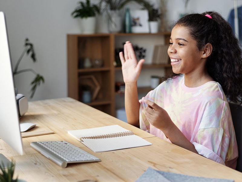 student smiling in front of computer