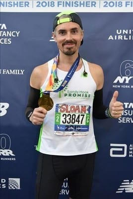 Sloan shows off his medal for finishing the NYC Marathon in 2018.