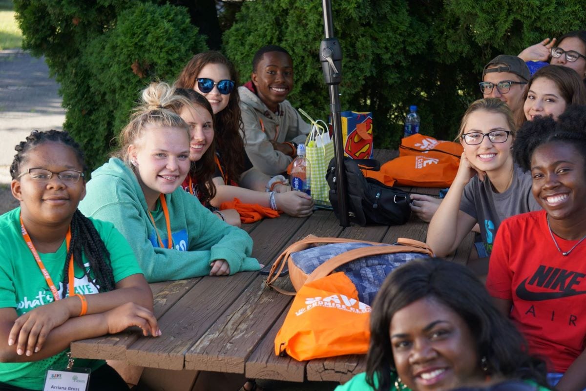 Arriana Gross and other members of our National Youth Advisory Board gather around a picnic table.