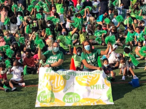 Elementary students wearing green for Start With Hello Week gather outside for a group photo.