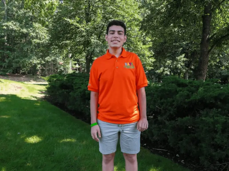 Student wearing an orange SAVE Promise Club polo