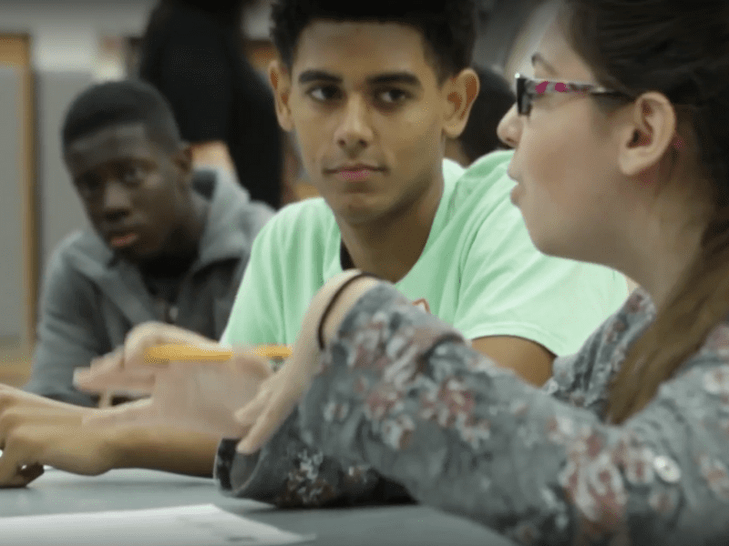 Group of students taking notes and having a conversation