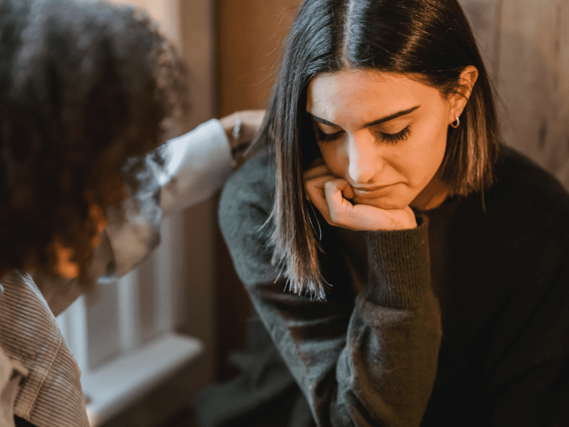 Girl comforting a friend who is sad