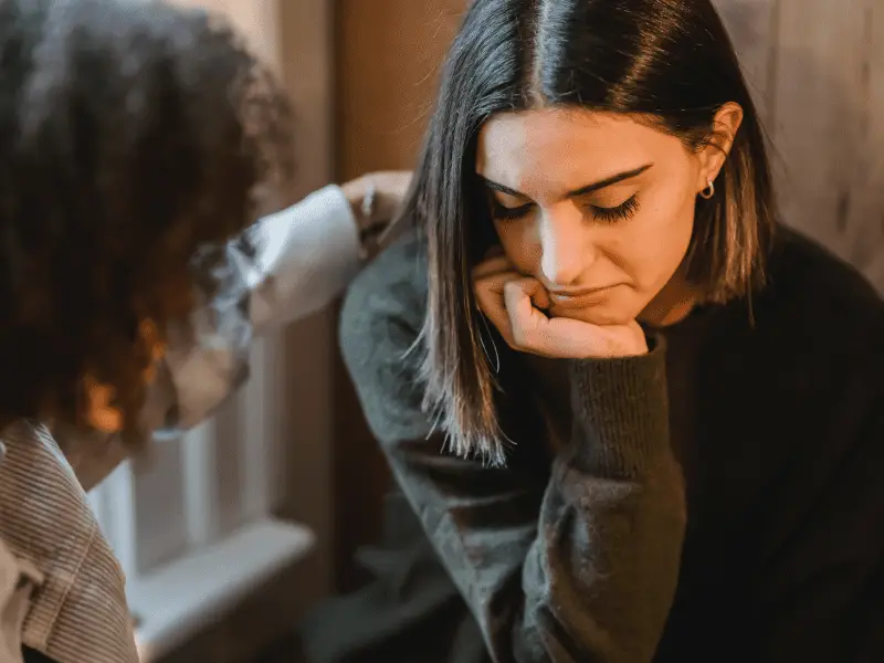 Girl comforting a friend who is sad