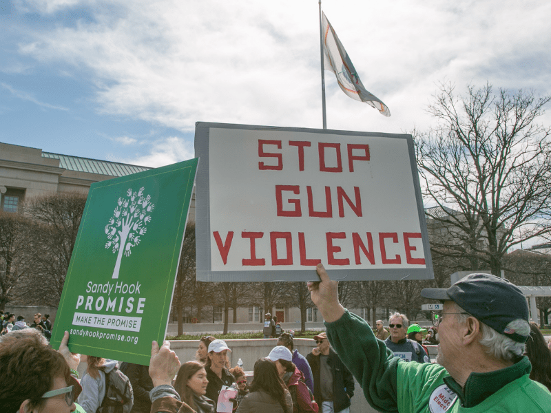 Sandy Hook Promise Supporters holding a "STOP VIOLENCE" sign. Gun violence is out of control in the U.S, but bipartisan gun safety progress is possible.