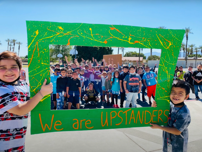 Group picture of students from Lyndon B. Johnson Elementary School behind a "We are Upstanders" frame.