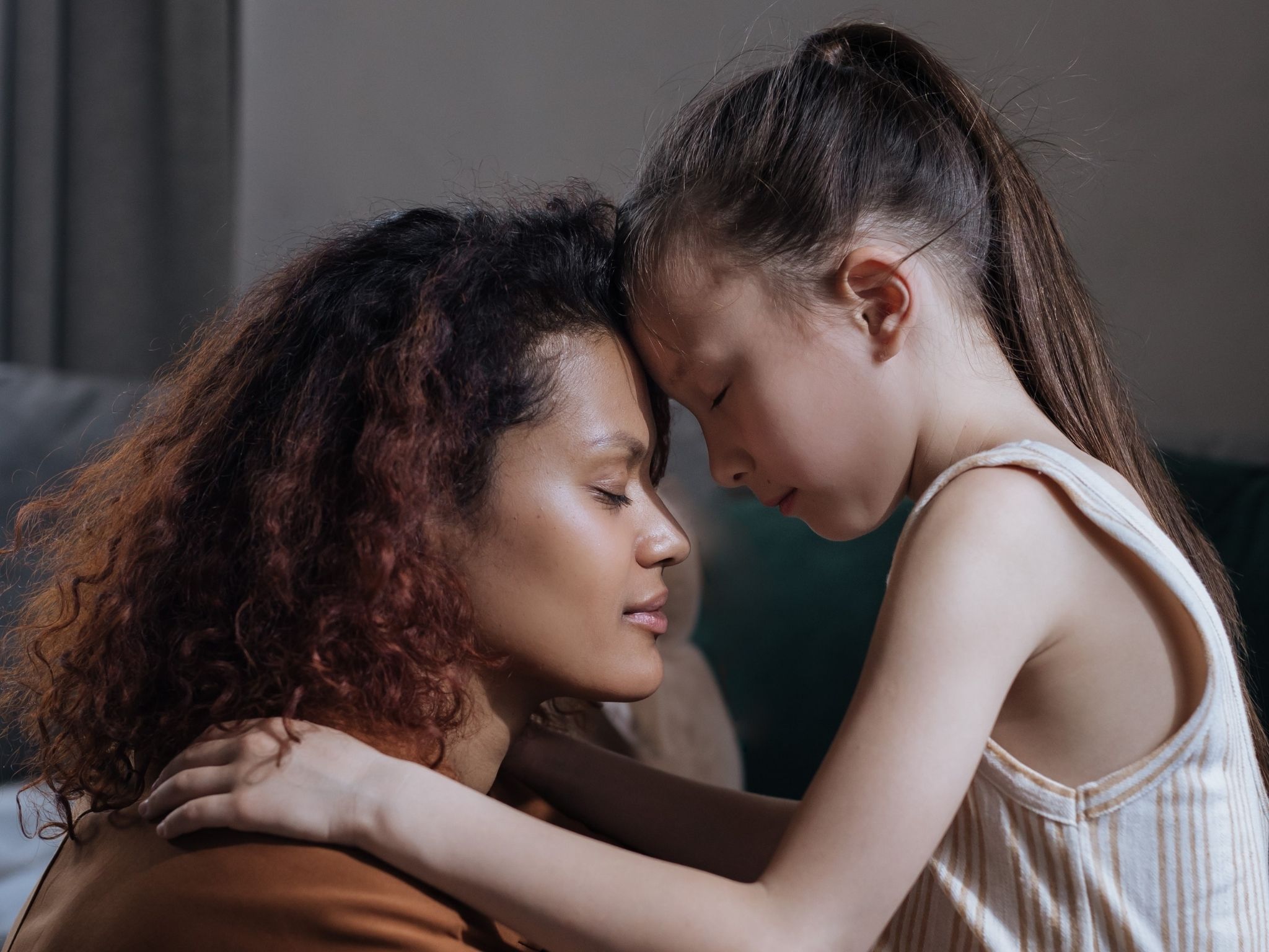 A caregiver comforts their child in a moment of kindness and connectedness.