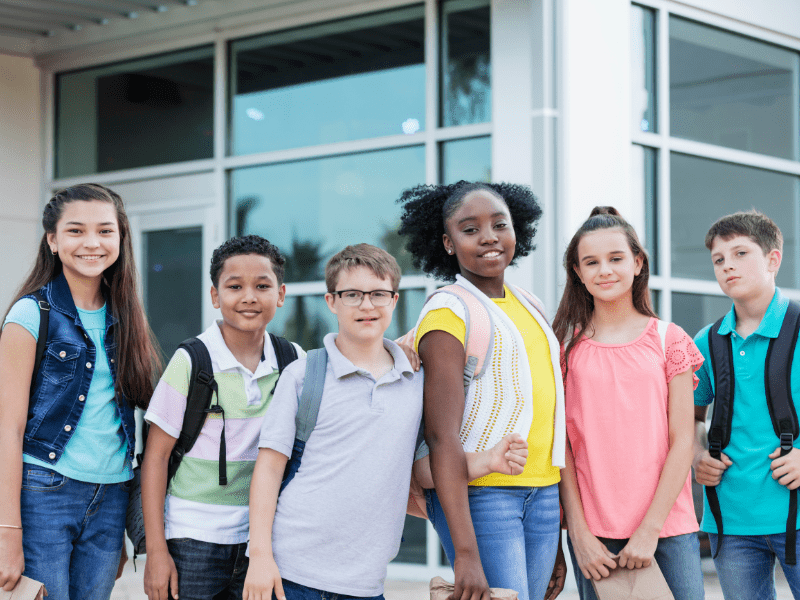 Group of middle school students standing together outside school