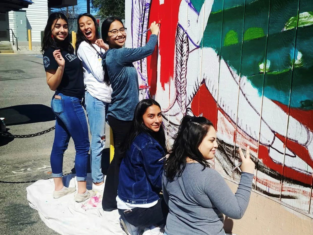 San Fernando students painting a wall mural