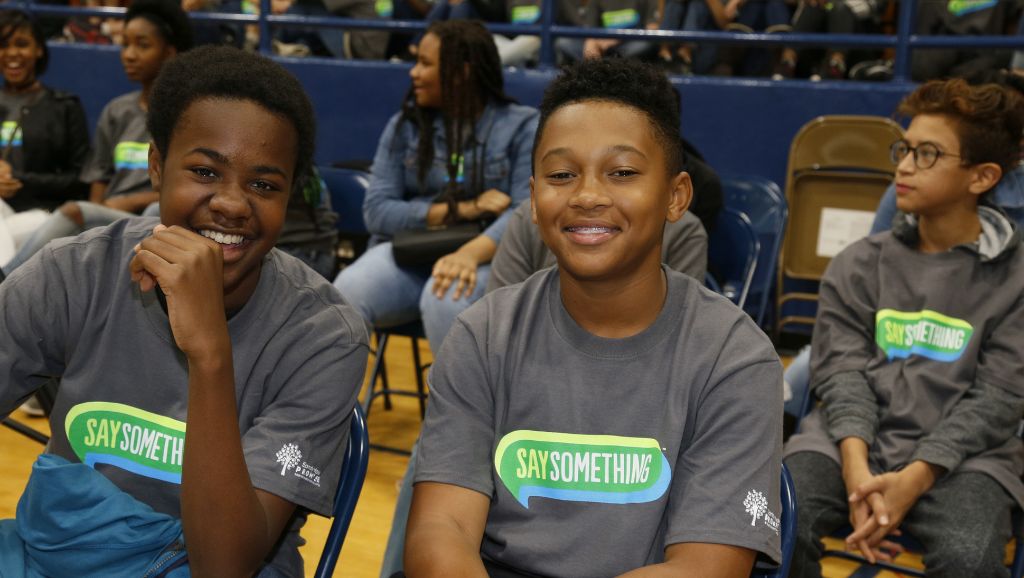 Three students wearing Say Something shirts.