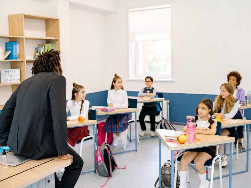 Teacher speaking to students in a classroom.