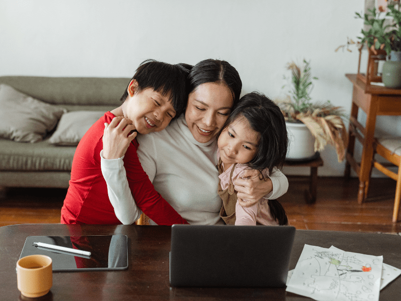 A trusted adult and children hugging