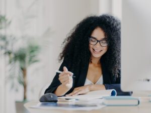 Woman writing at computer desk for matching gift page