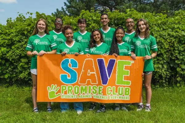 Youth holding a banner that reads "SAVE Promise Club"