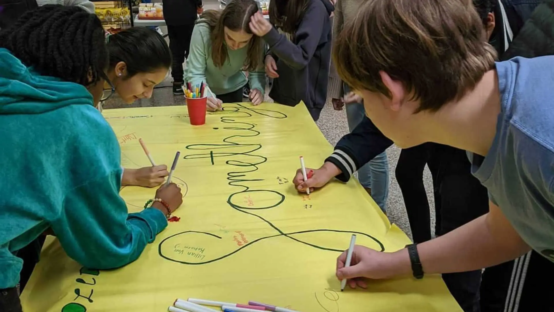 Students working on a Say Something Week poster.