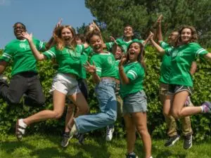 Group of students jumping and wearing Sandy Hook Promise green t-shirts.