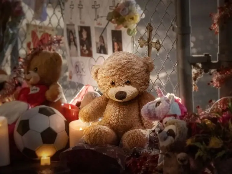 A teddy bear and toys at a memorial shrine.